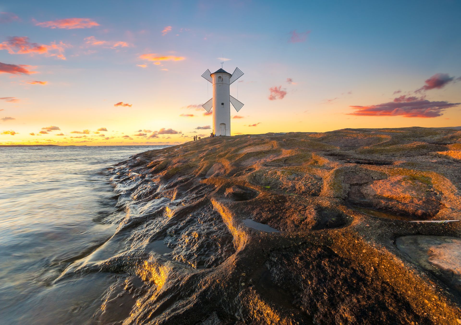 Beautiful sunset over a windmill-shaped lighthouse, Swinoujscie, Poland